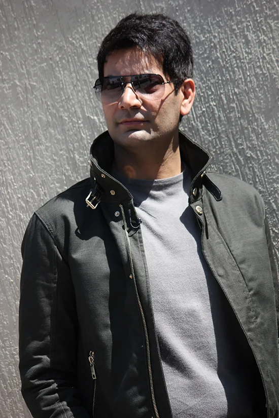 Original portrait of Jasbir Jassi wearing a black jacket and sunglasses